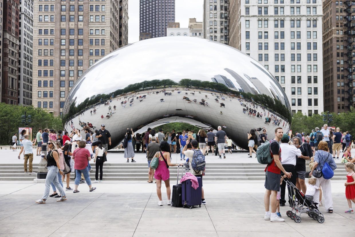 Visitors take photos of the Cloud Gate sculpture, also known as "The Bean," at Millennium Park on Sunday